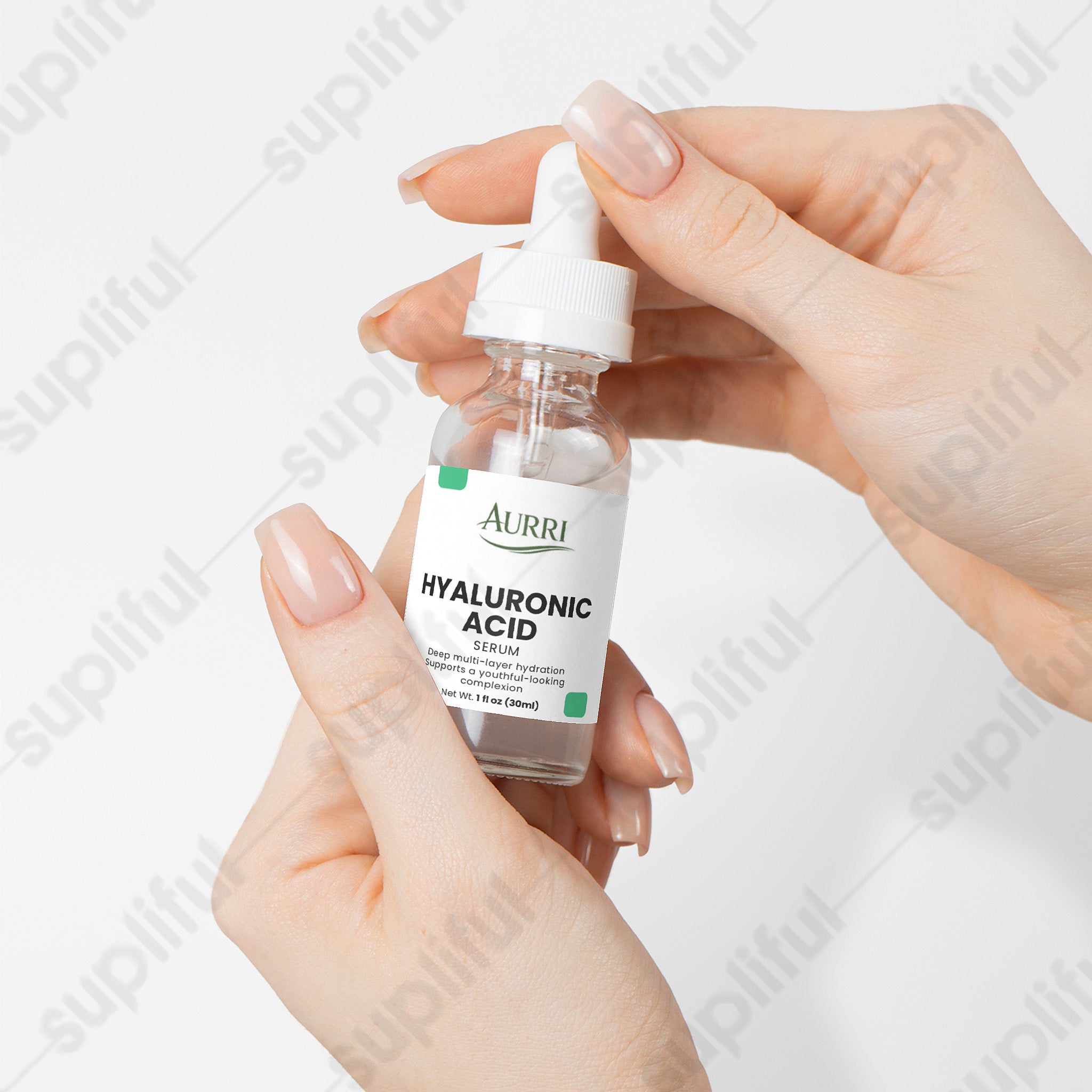 Hand holding hyaluronic acid serum dropper bottle for skincare on white background